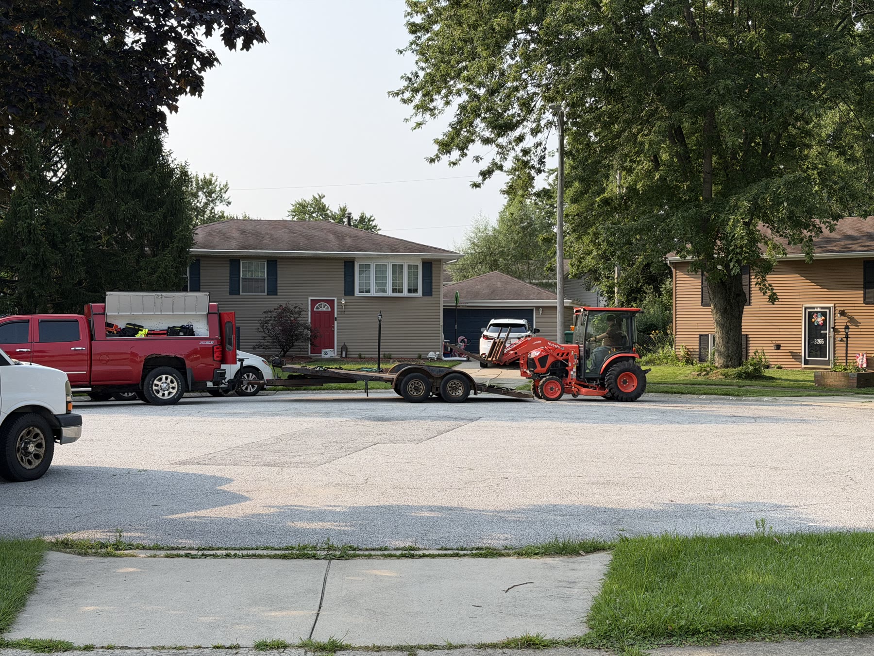 The pickup, car trailer, and tractor positioned in the tight cul-de-sac.