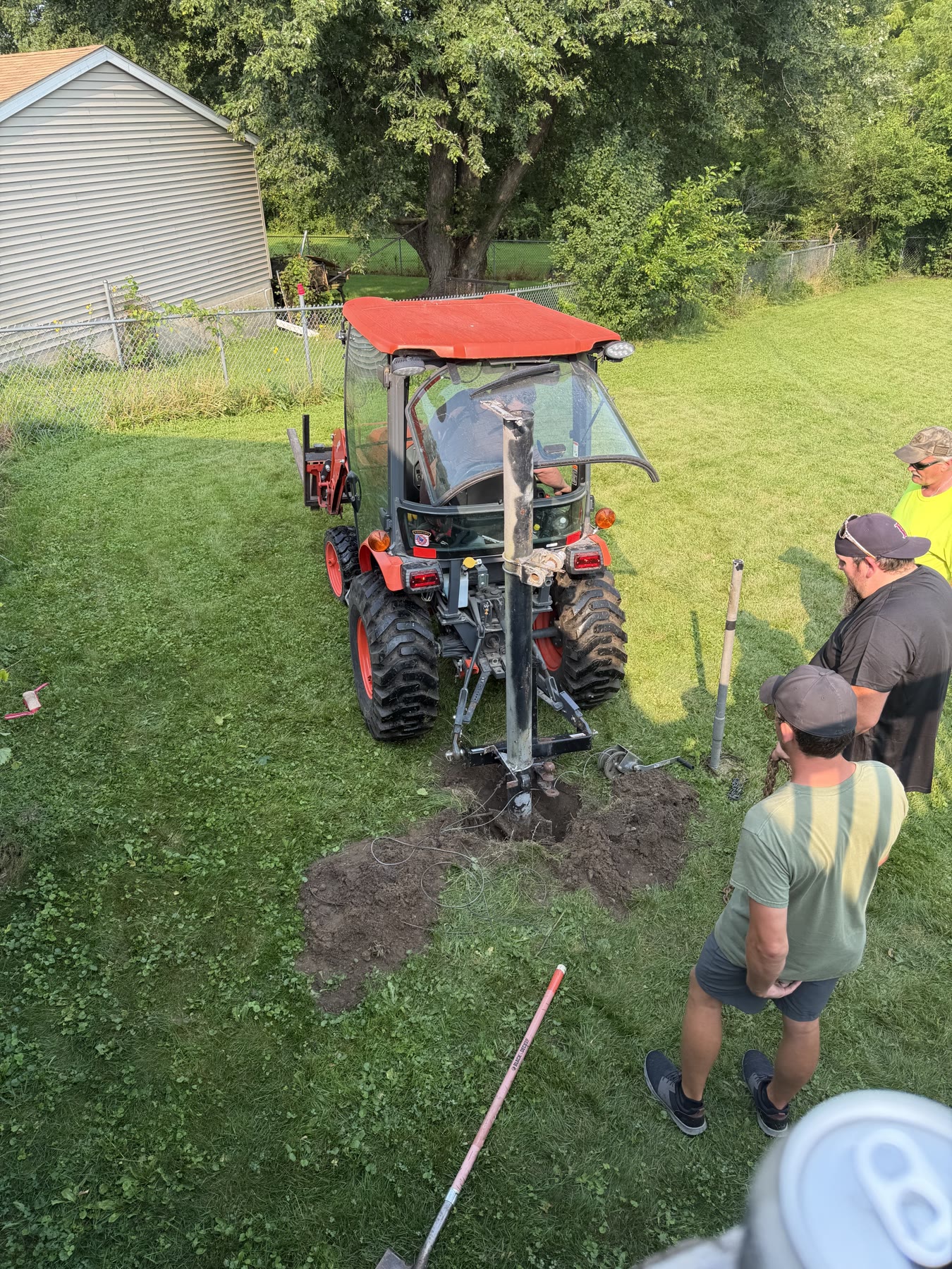 The tractor’s three-point hitch and chain set up to pull the buried mast.