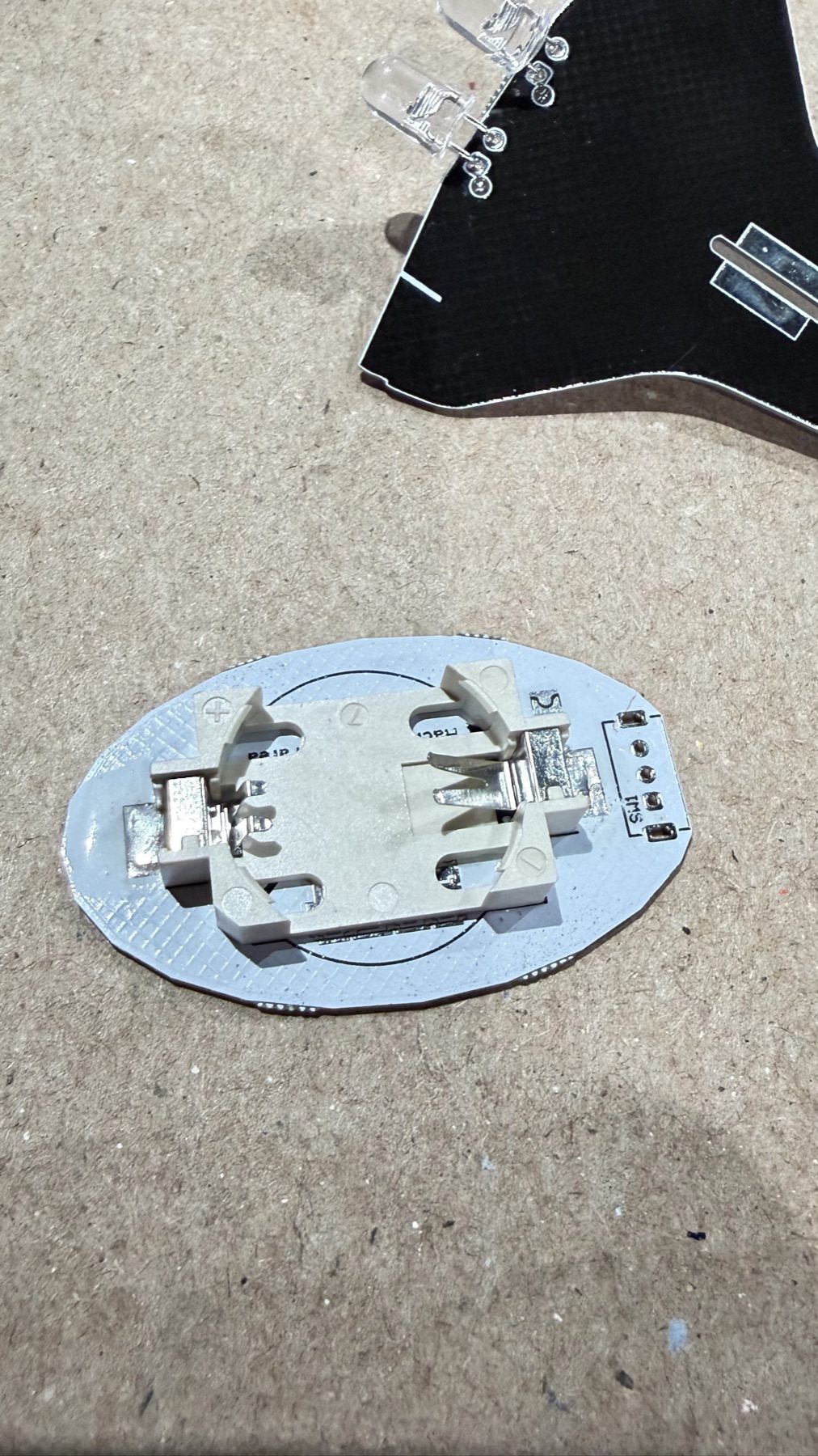Electronic components soldered onto the round base PCB.